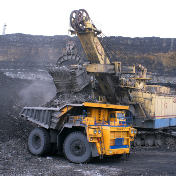 Heavy mining equipment in operation, featuring a large dump truck and excavator, showcasing coal extraction in a mining site, relevant to mining courses in Queensland.